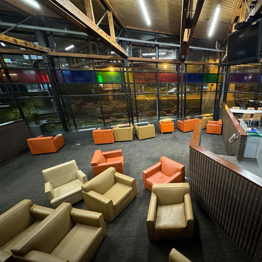 This is a photo of the lower half of the cafeteria where the couches can be rearranged to eat lunch and face the window. The people who utilize this space is often students who eat alone or would prefer a more confortable space to eat/study.</li>
          </ul> 